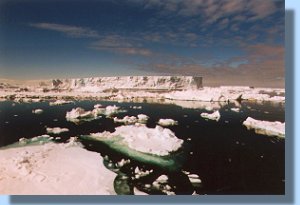 A dead calm sea with icebergs floating everywhere