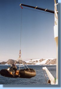 A zodiac is lifted into the water