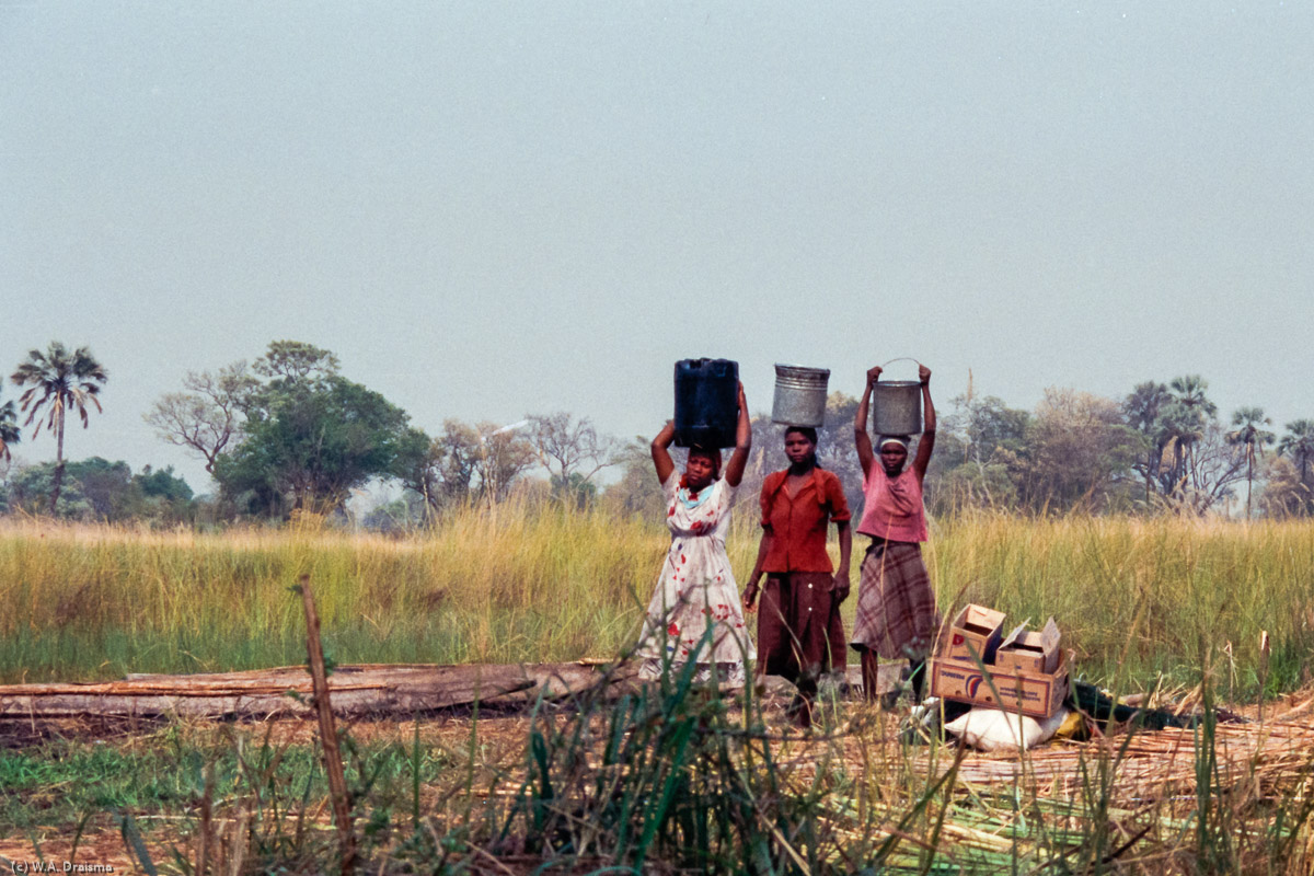 Early in the morning the village's women go to the river for water balancing the filled buckets on their heads.