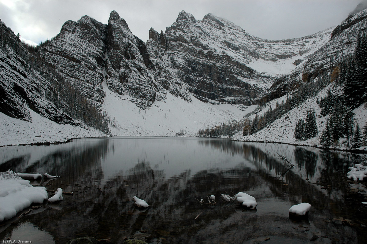 The surface of Lake Agnes mirrors the towering peaks surrounding it. Lake Agnes was named in honour of Lady Agnes Macdonald, second wife of Canada 's first prime minister.
