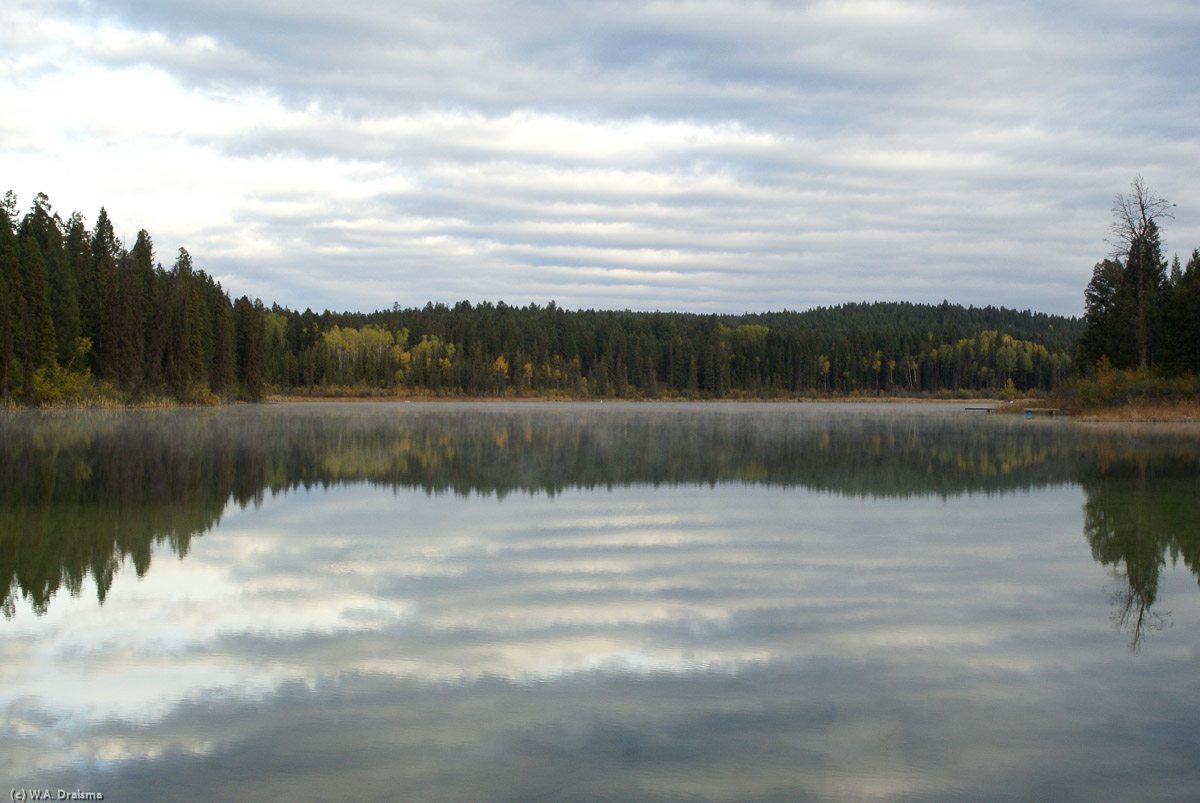 A lake reflects its surroundings in the early hours of morning.