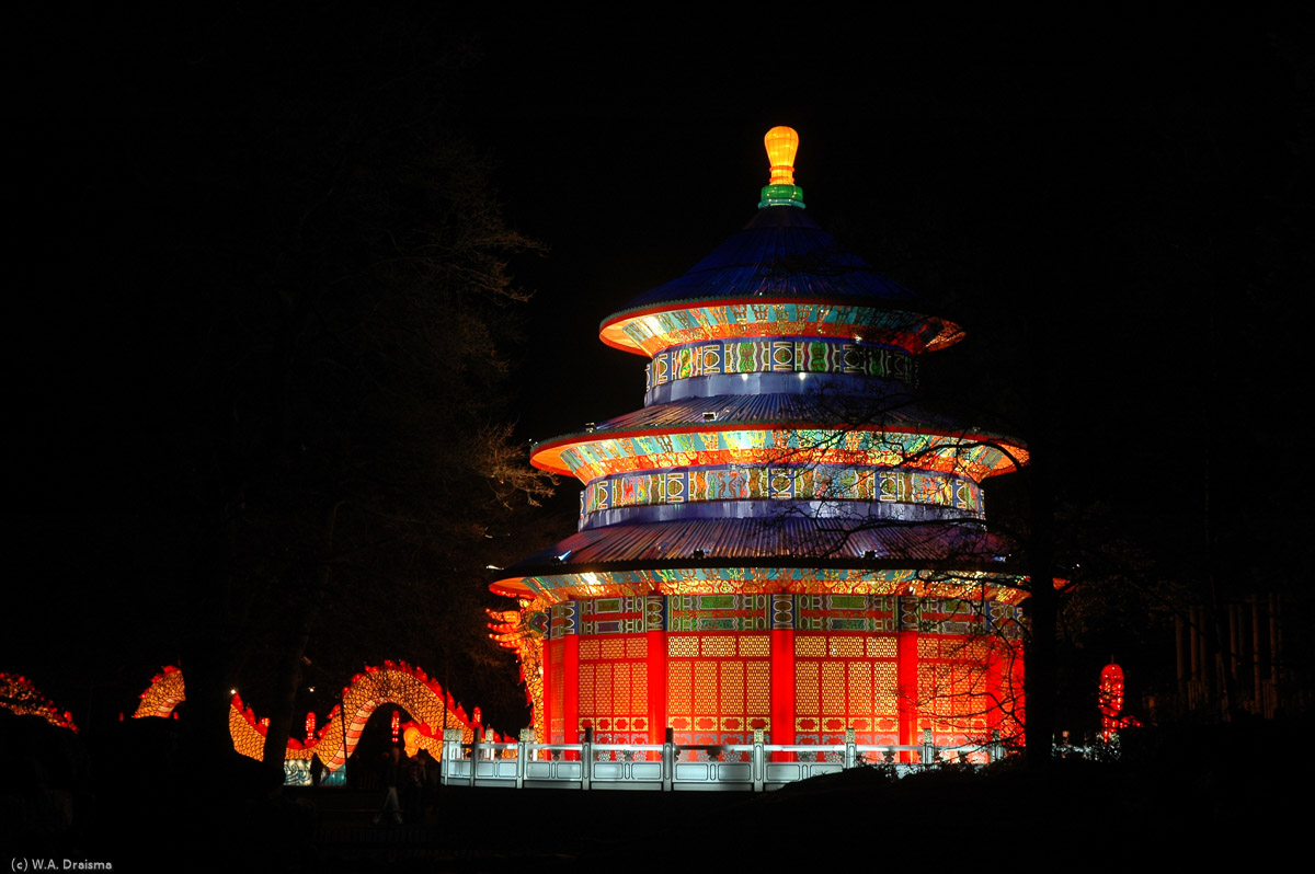 In the distance an illuminated pagoda towers above the surrounding area.