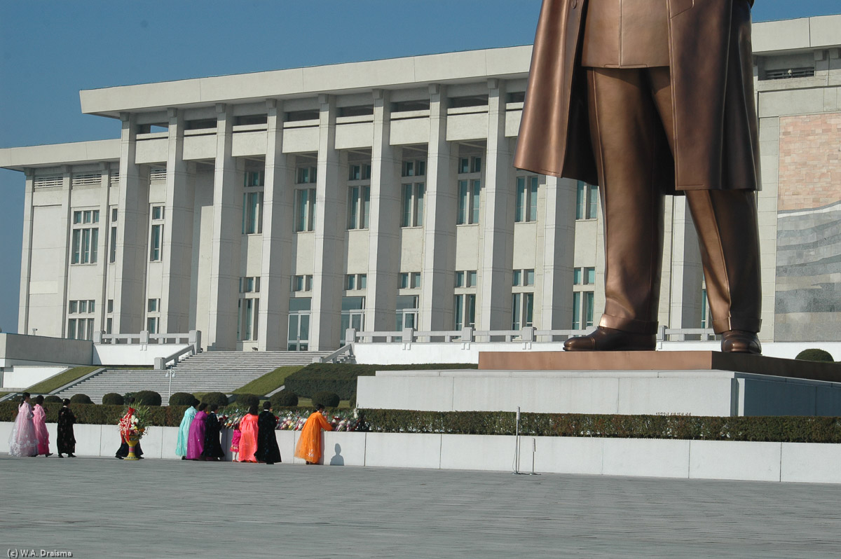 The Grand Monument is a place of devotion. North Koreans, many of them in traditional dress pay hommage to the Great Leader by placing flowers at his feet.