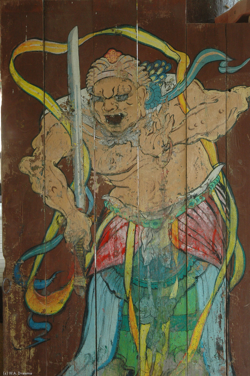 The wooden entrance doors to Songbul Temple show colorful paintings of persons. Are they guards? Or are they deities?