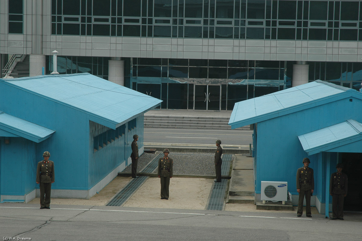 The actual border is the thin concrete strip guarded by North Korean soldiers. Crossing the line is illegal, will probably get you shot and will result in a severe diplomatic crisis.