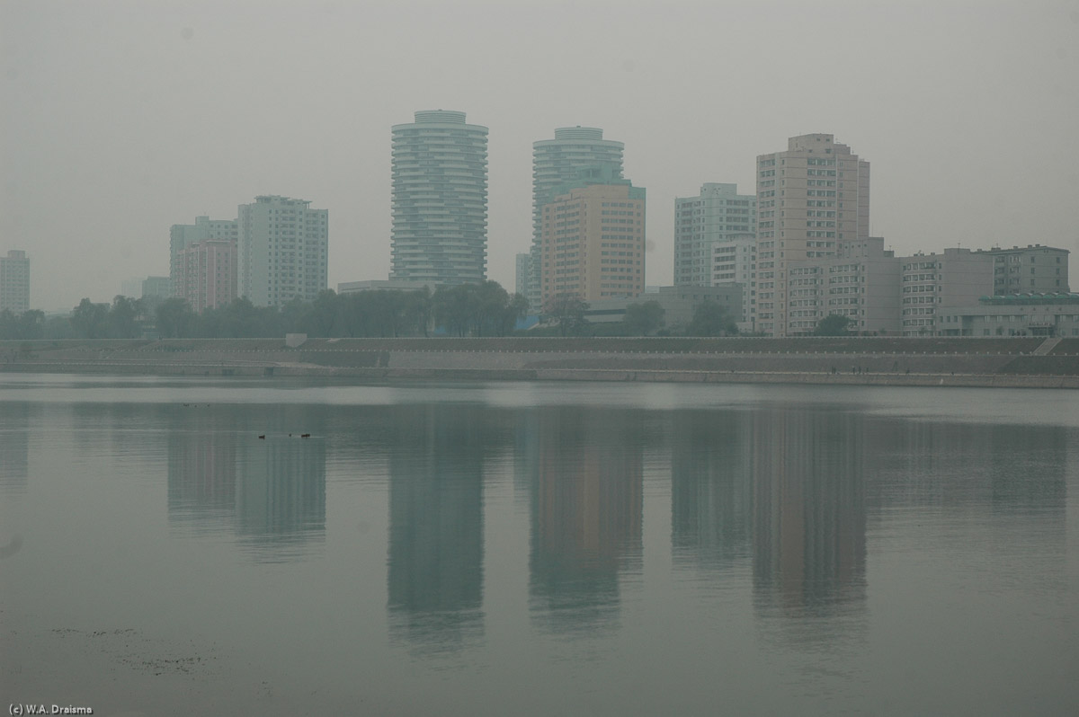 It's the morning of our last day in North Korea. Buildings are mirrored in the calm waters of the Taedong. Ten minutes without guides, ten minutes to walk on your own, though on Yanggak island only.