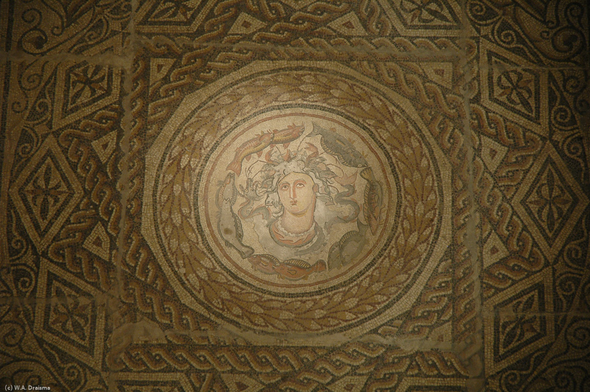 The floor of the smaller room connecting the Leptis Magna and Sabratha rooms is covered by a mosaic from Roman Oea. The centre of the mosaic is surrounded by a much larger area with geometric designs. Seated on cushions people could admire the portrait and scenes in the middle.