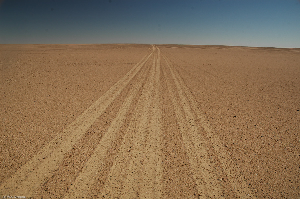 Travelling eastwards, the black volcanic sands of Waw an Namus turn brown again. For the next hours we travel through a flat monotonous landscape only stopping at a water well to refill our supply of drinkable water.