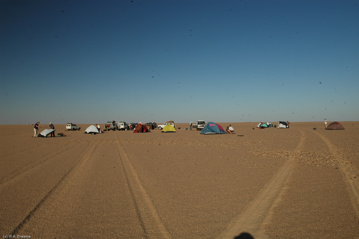 It takes more than an hour to come to a decision but finally we're escorted to a place where we're allowed to camp. A perfect spot: 24°29"47.6' North and 17°55"53.3' East, only a few hunderd meters from the central line. We set up camp and relax. At the horizon we notice a police car and the lights of the official camp.