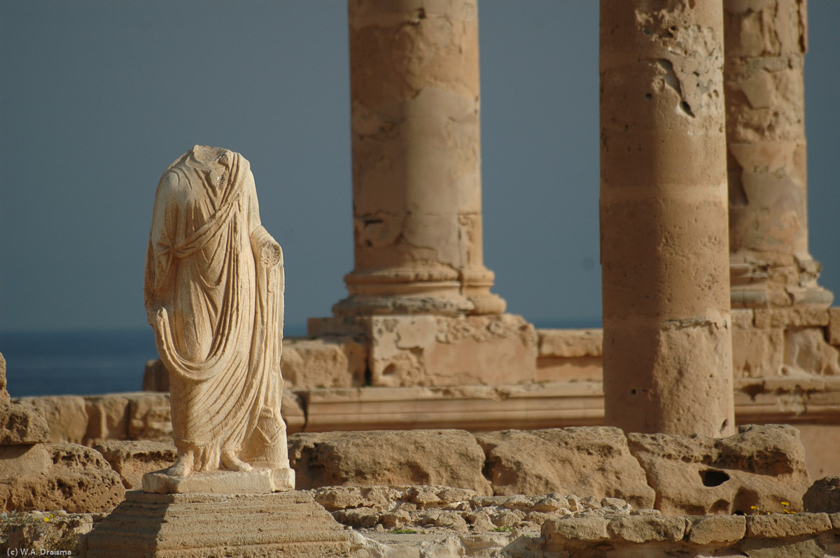 In front of the Temple of Liber Pater and next to the elevated Antonine Temple, dedicated to the Roman emperor Antoninus Pius, stands the headless statue of Flavius Tullus, a 2nd-century citizen who commisioned an aquaduct to bring water to Sabratha.